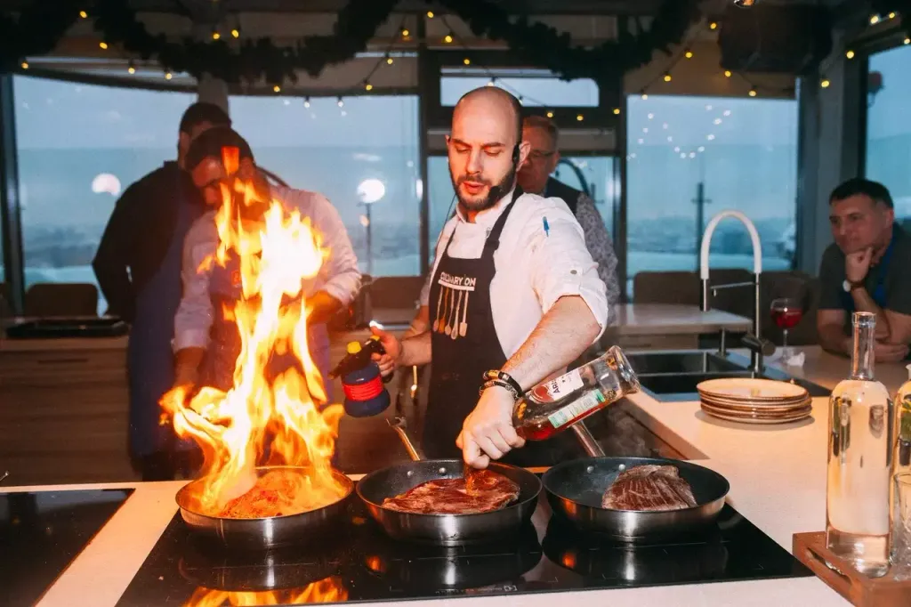 Шеф-повар EventyOn готовит мясо с открытым огнём на кулинарном мастер-классе