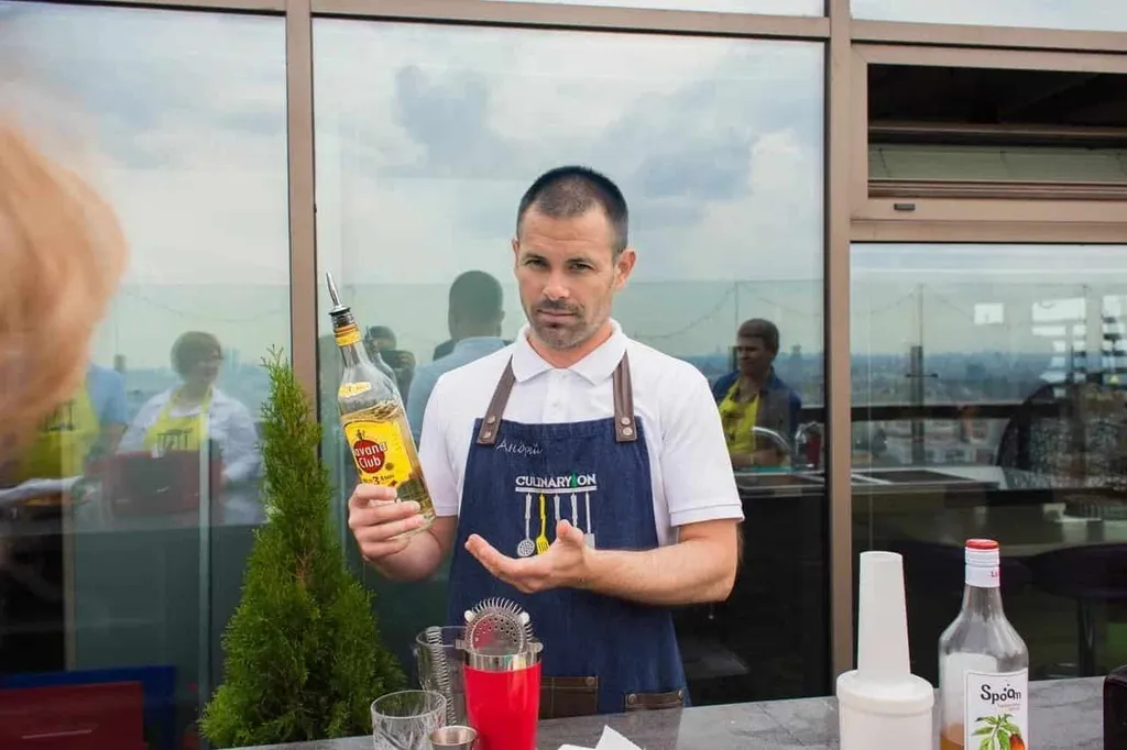 Бартендер Андрей показывает бутылку рома Havana Club на коктейльном мастер-классе EventyOn